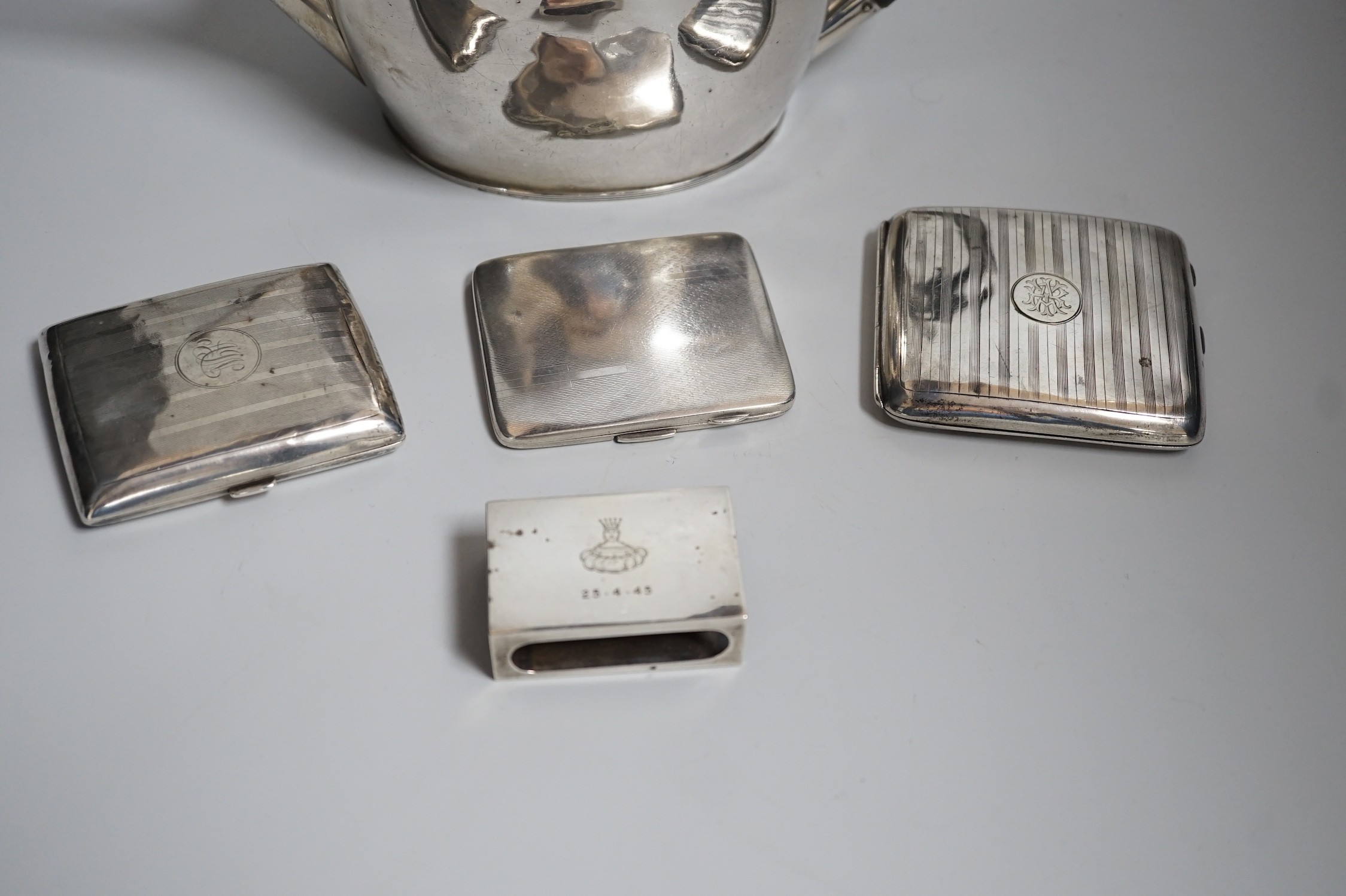 A George V silver oval teapot, Birmingham, 1913, three silver cigarette cases and a silver matchbox holder, gross weight 29oz.